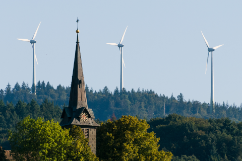 Dörfliche Kirche vor Windenergieanlagen    